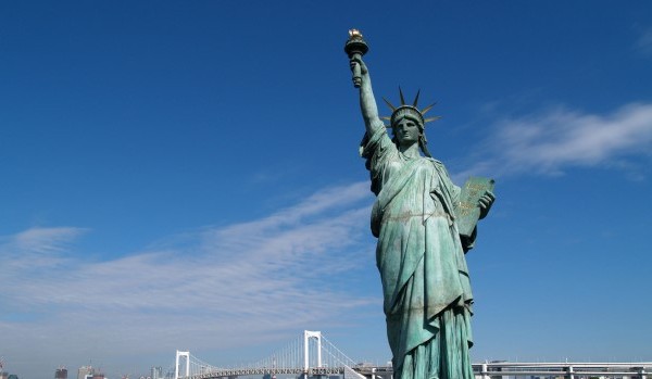 A statue of a person with Statue of Liberty in the background