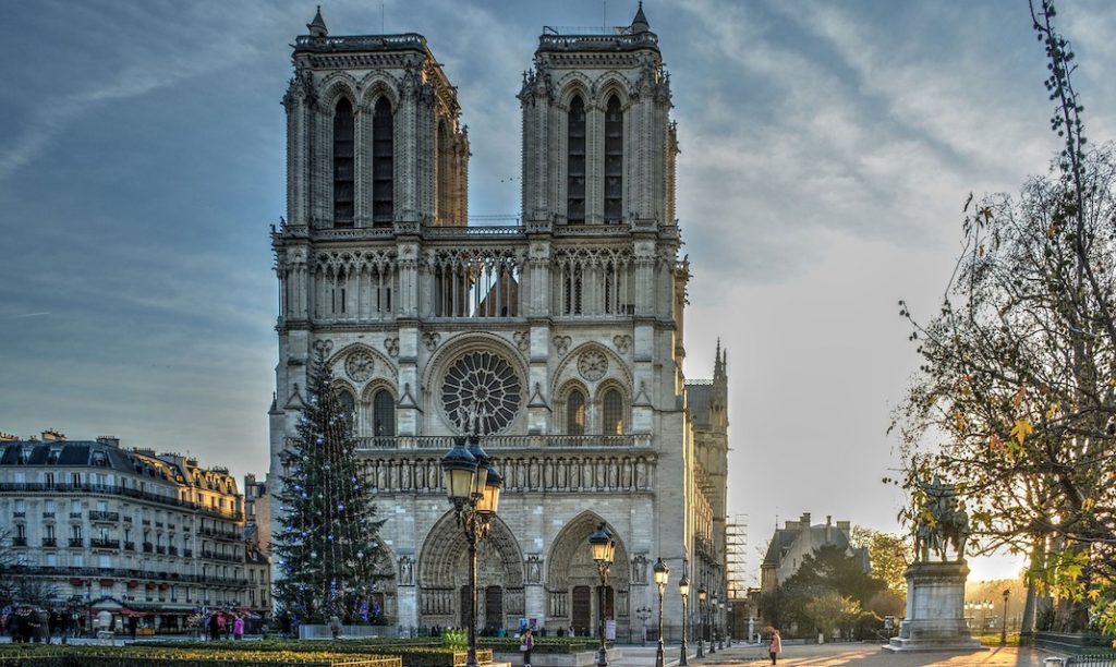 A large clock tower in front of Notre Dame de Paris
