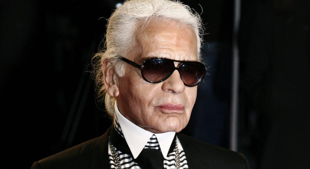 A person wearing a suit and sunglasses posing for the camera
