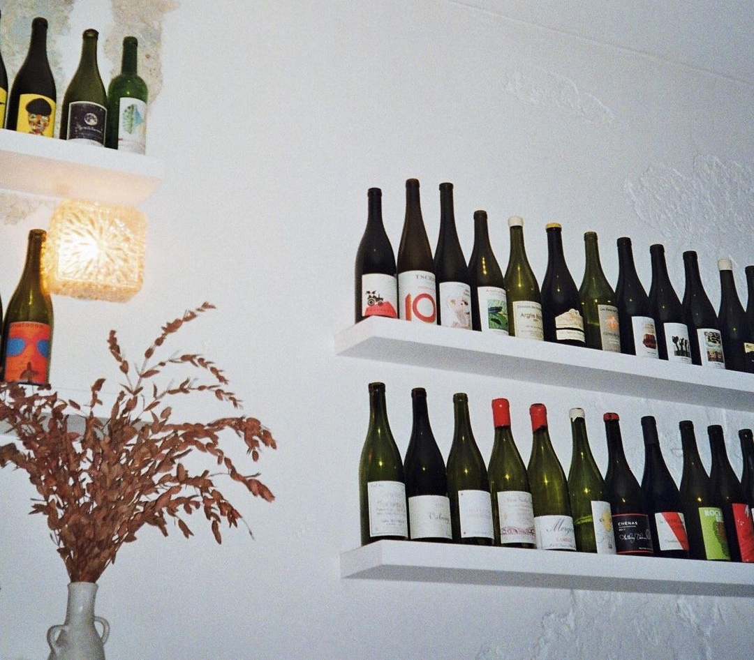 Shelves of wine bottles against white walls