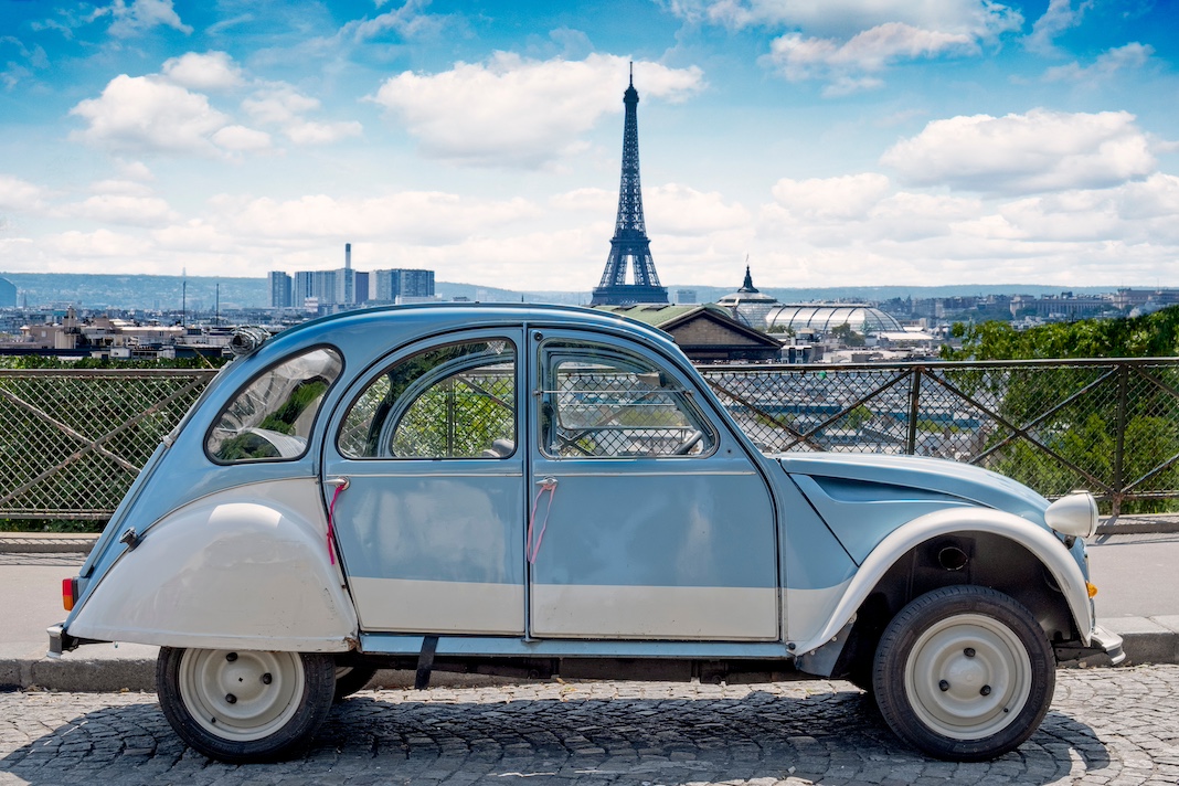 PARIS, FRANCE - JULY 28, 2018: Historic Citroen 2 CV car standing in front of the Paris cityscape. Citroen 2 CV represents the Paris lifestyle like no other object in France.