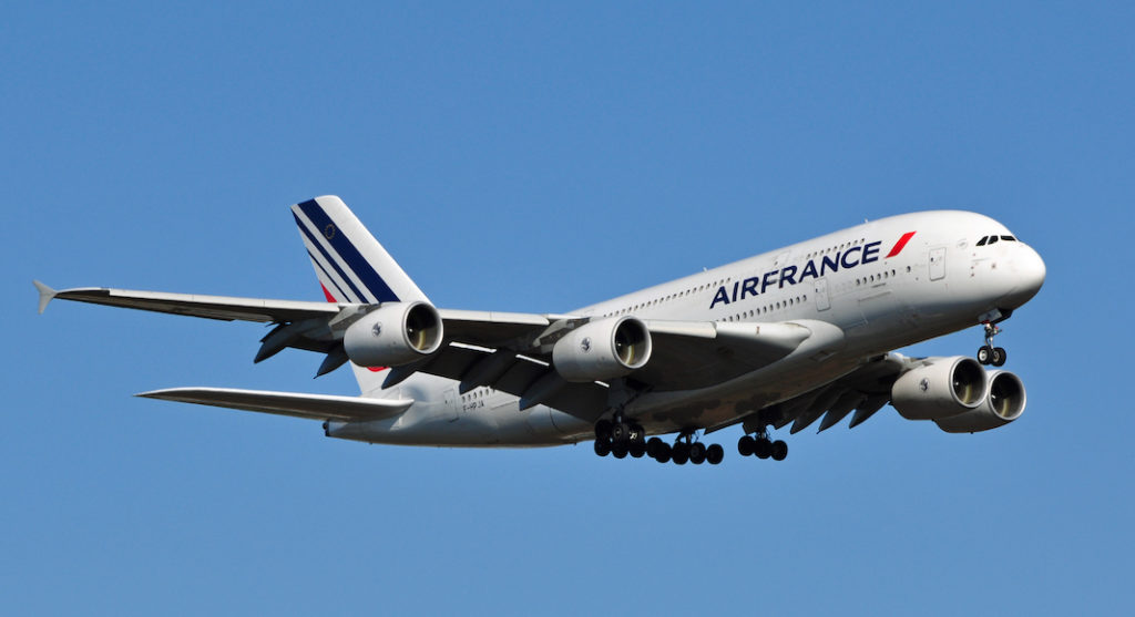 A large passenger jet flying through a blue sky