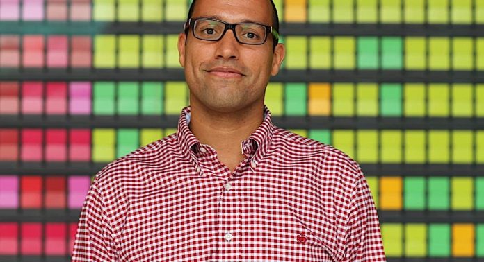 A man wearing glasses and smiling at the camera