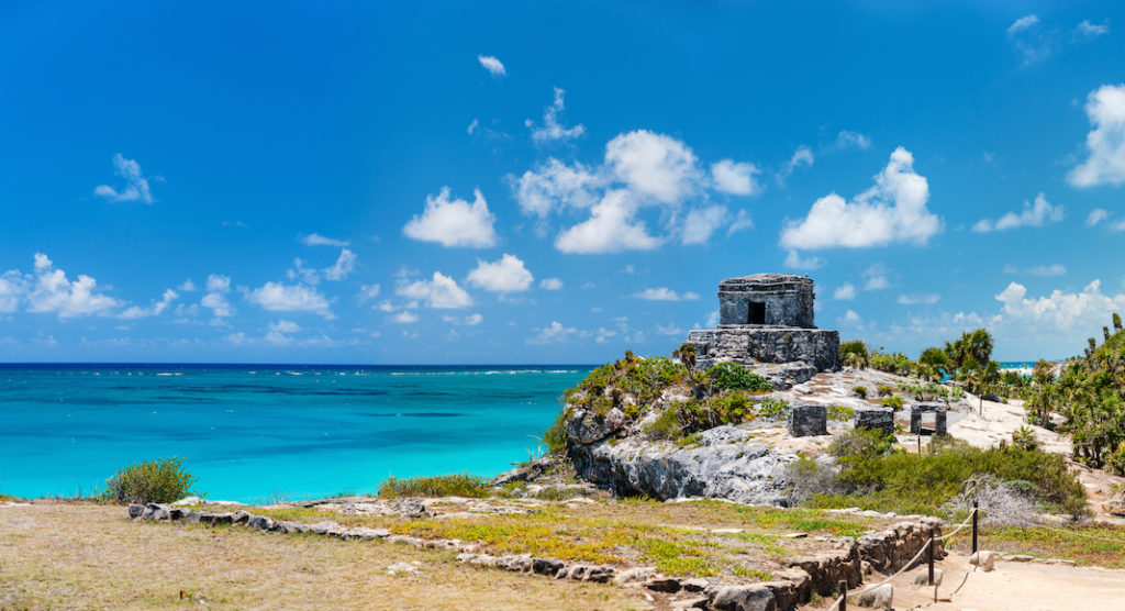A large body of water with Tulum in the background