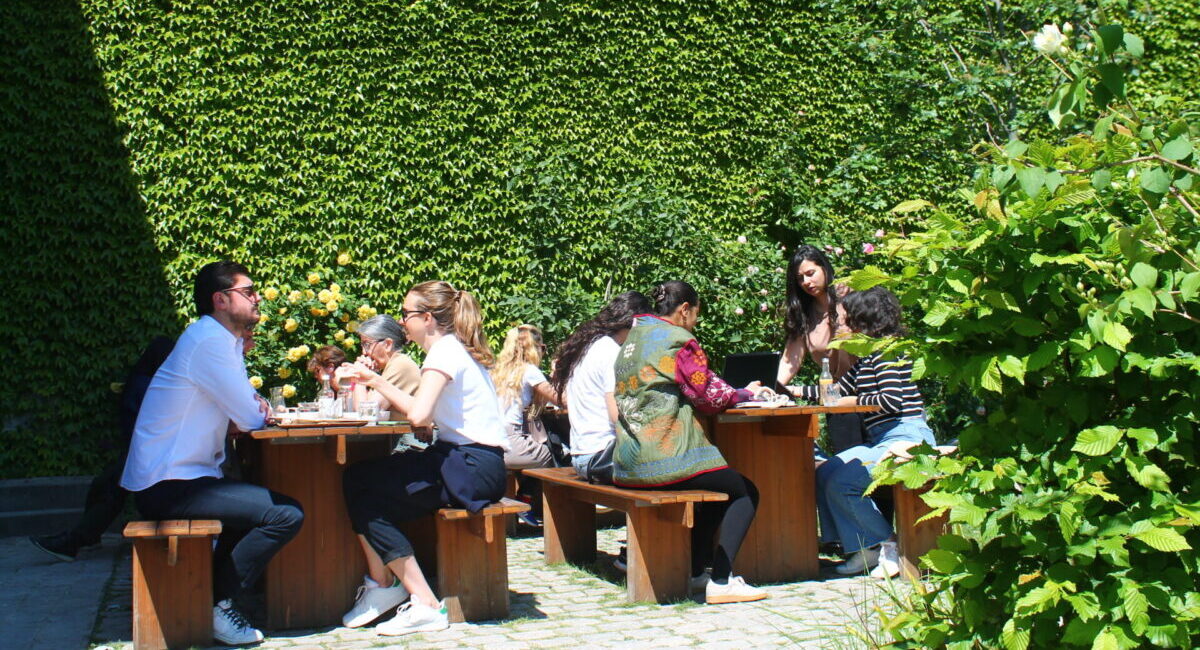 People dining against wall of ivy