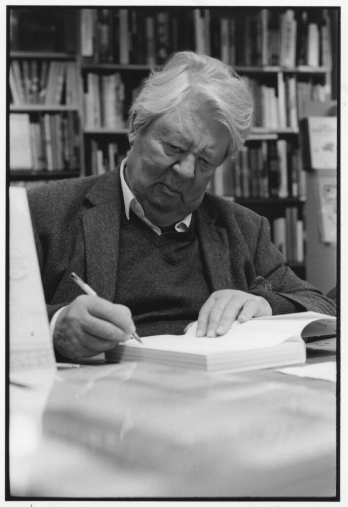 A person sitting in front of a book shelf