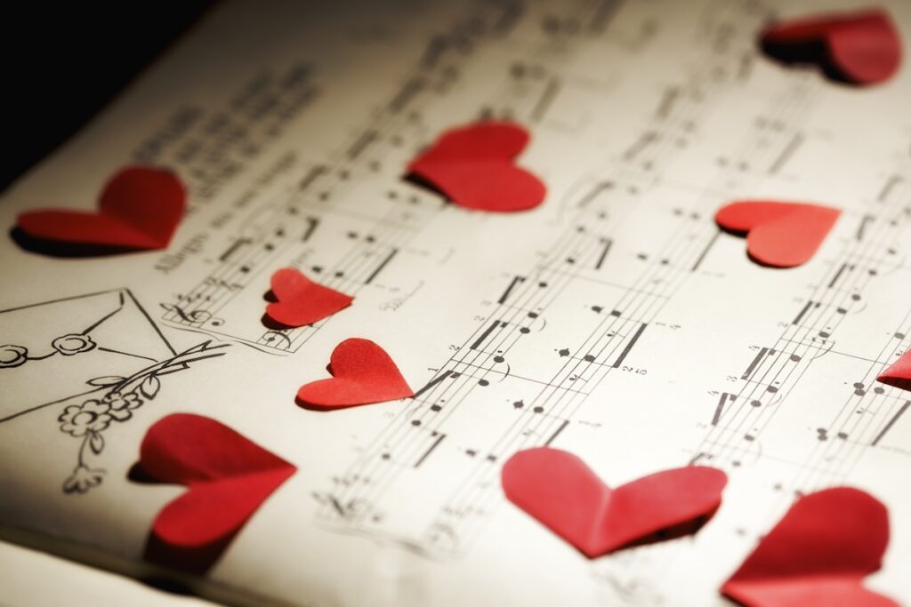 Closeup of red paper hearts on yellowed music book