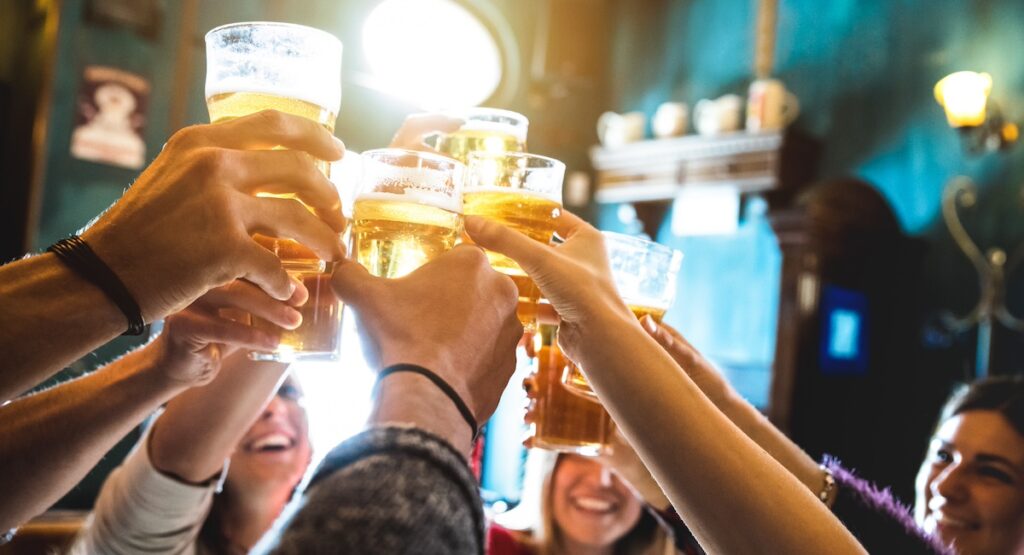 Friends clinking pint glasses of beer