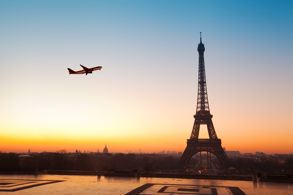 Airplane flying in the sky by the Eiffel Tower in Paris