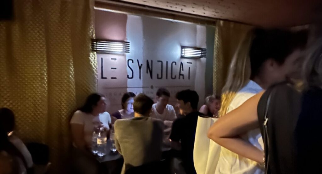 Le Syndicat sign on painted whitewashed bar walls