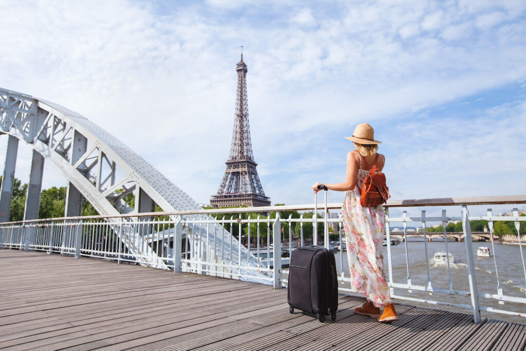 travel to Paris, Europe tour, woman with suitcase near Eiffel Tower, France