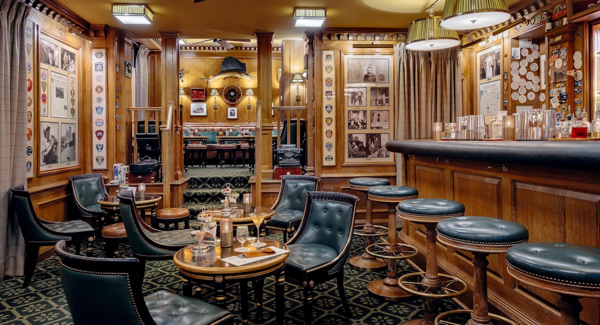 Bar interior with warm wood and green leather chairs