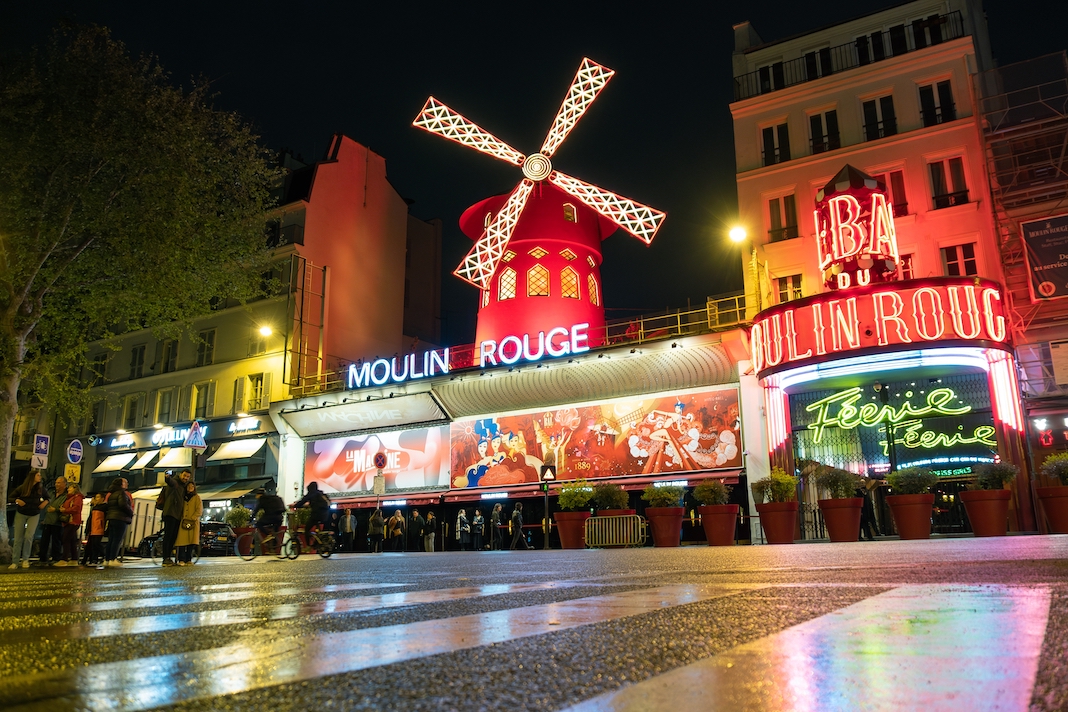 Paris, France - April 24 2023: the exterior of Parisian Moulin Rouge at night in Paris, France. The Moulin Rouge is the most famous cabaret venue in France