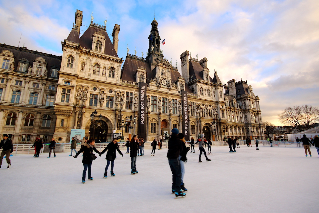 PARIS - JANUARY 30, 2015: Parisian City Hall (Hotel de ville) with memorial banners "Je suis Charlie" and with unknown people skating on the ice rink, on January 30, 2015 in Paris, France.
