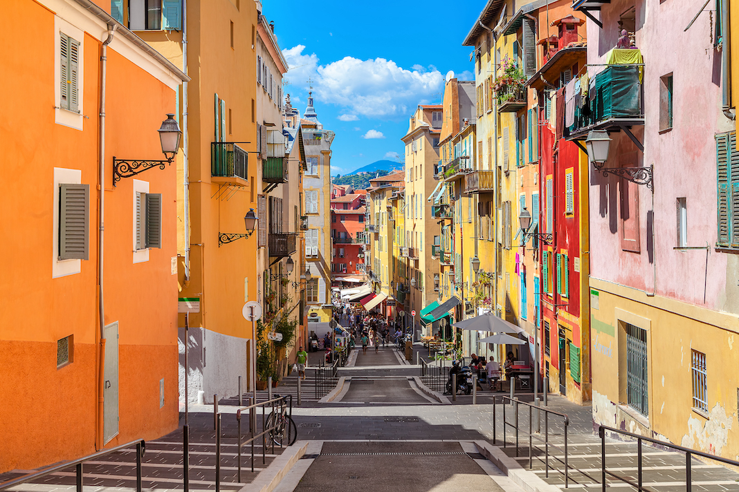 NICE, FRANCE - AUGUST 23, 2014: Narrow street in old part of Nice - fifth populous city and one of the most visited in France, receiving 4 million tourists every year.