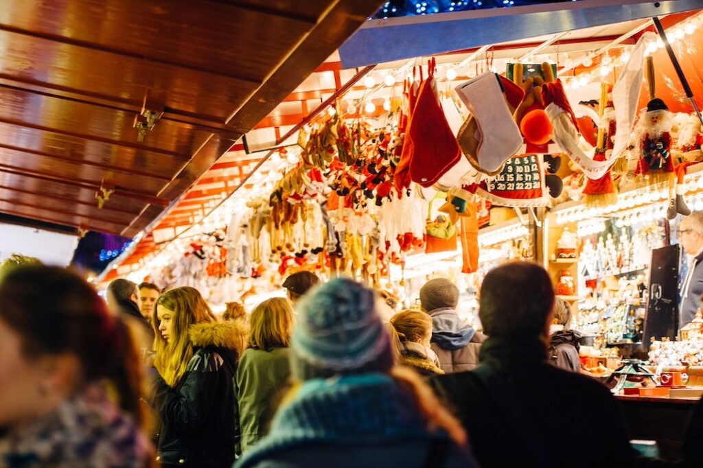STRASBOURG, FRANCE - NOV 28, 2015: Busy Christmas Market Christkindlmarkt in the city of Strasbourg, Alsace region, France with people admiring Christmas gifts