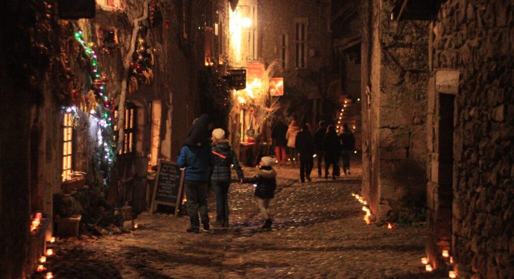 A family walking in a street at night. 