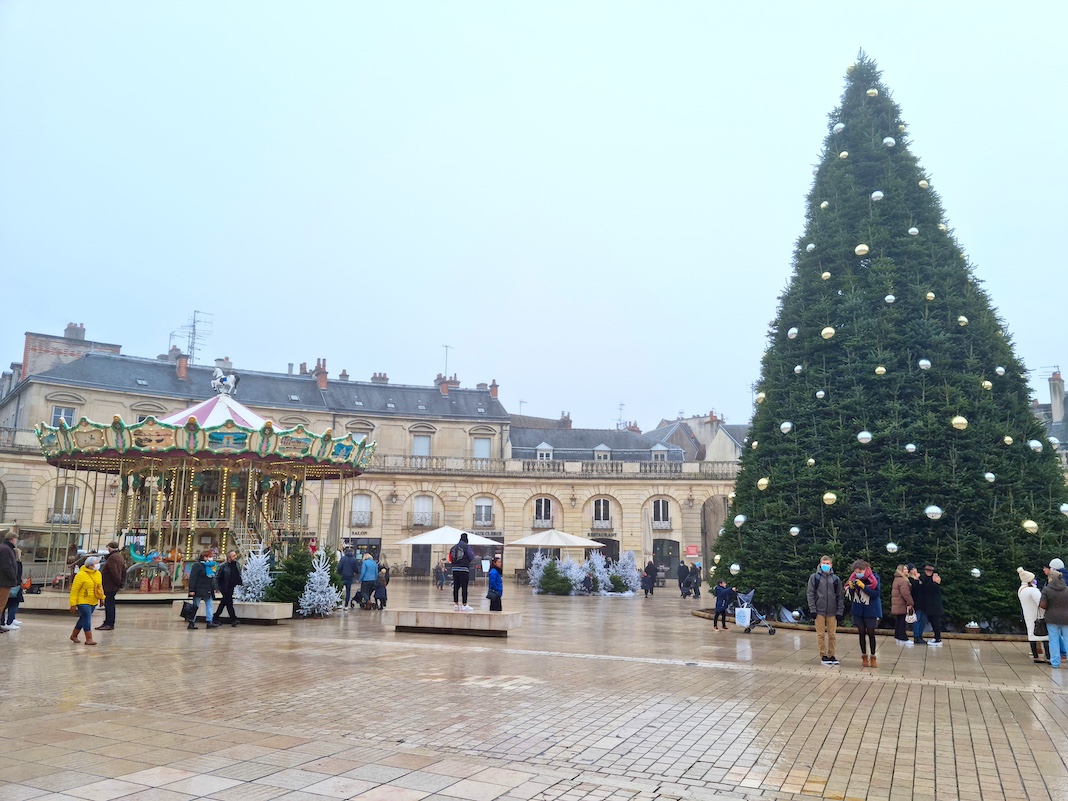 Dijon, France - 31 December, 2022: People walking in the Liberation square (Place de la Liberation) decorated for Christmas.  The pedestrian square is located in the center of the history old town.