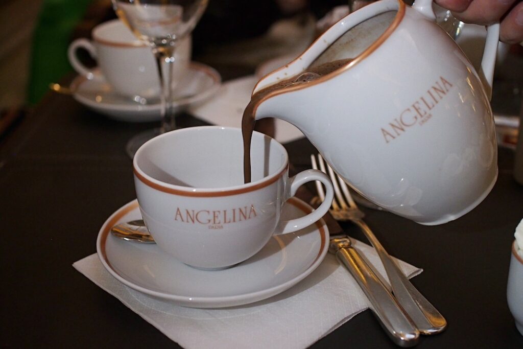 Angelina branded pitcher of hot chocolate being poured into tea cup