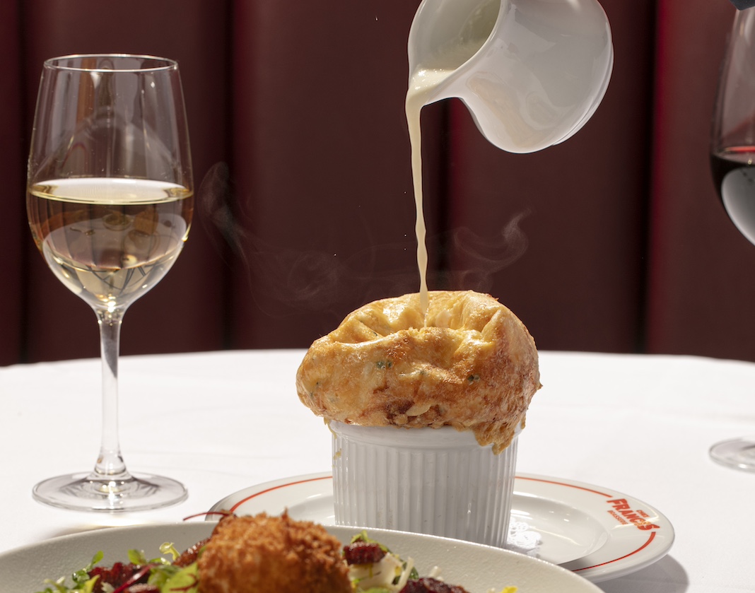Soufflé and salad against red leather banquette