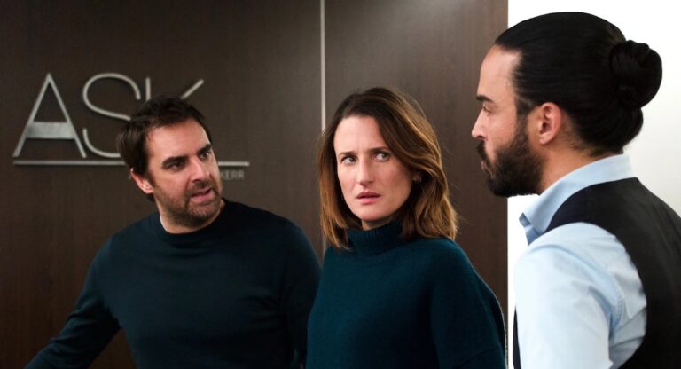 Woman and two men in front of office door