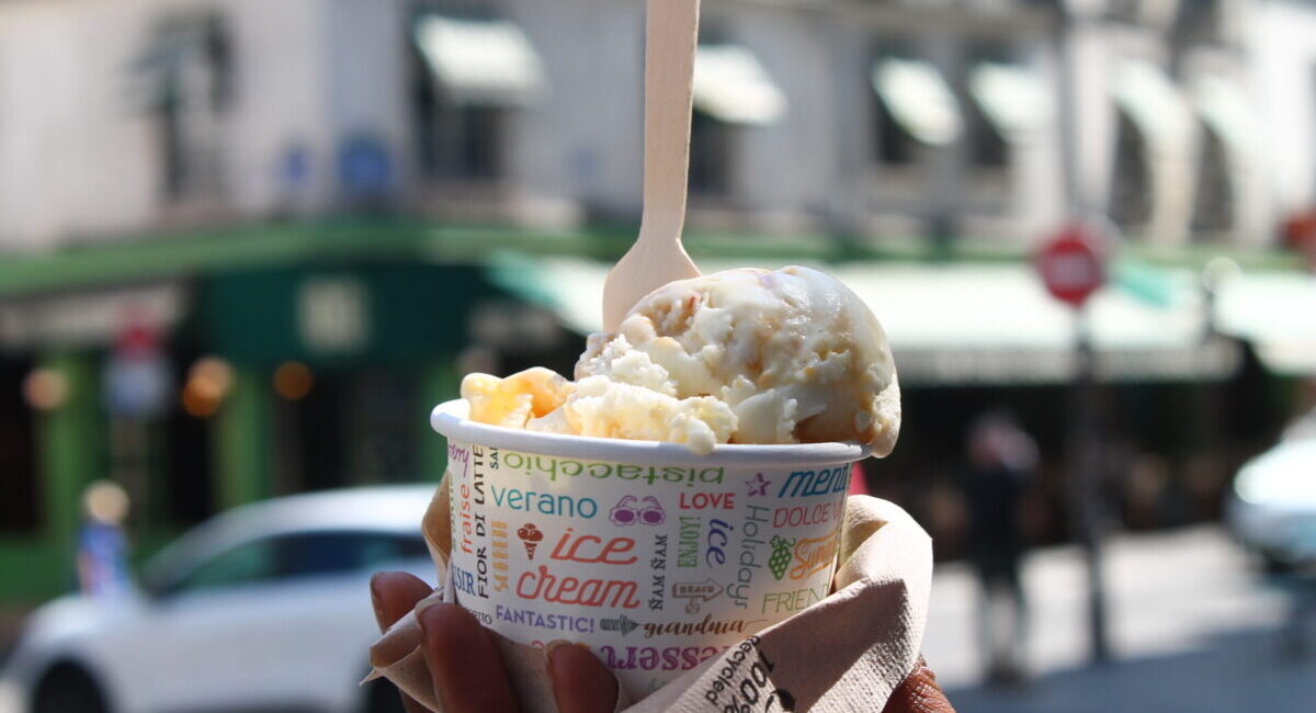 Ice cream in paper cup with wooden spoon