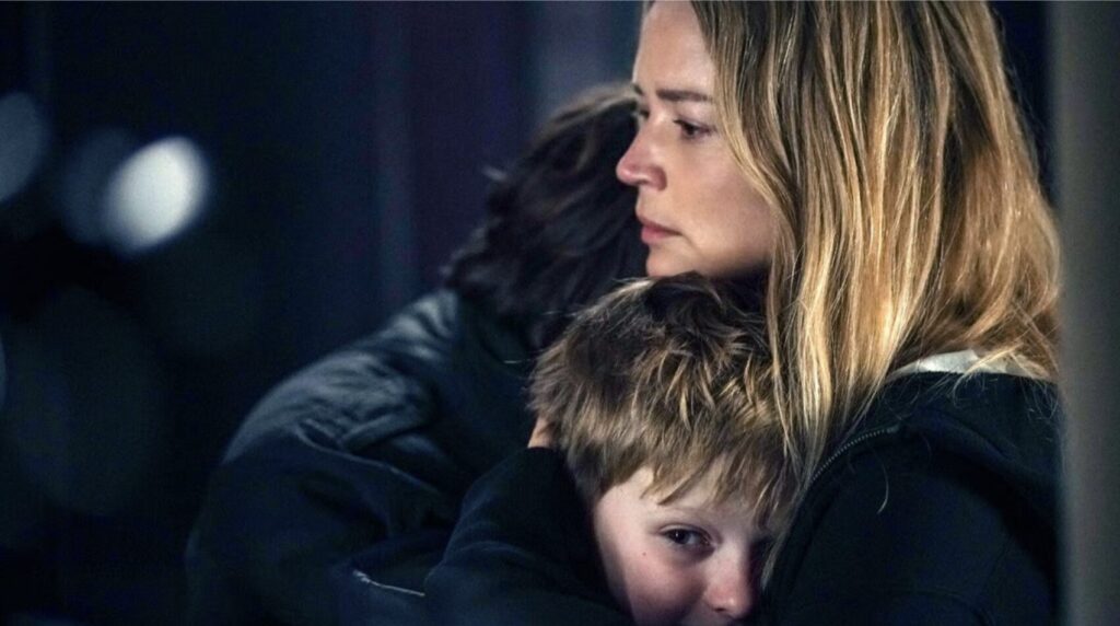 A woman hugs her sons