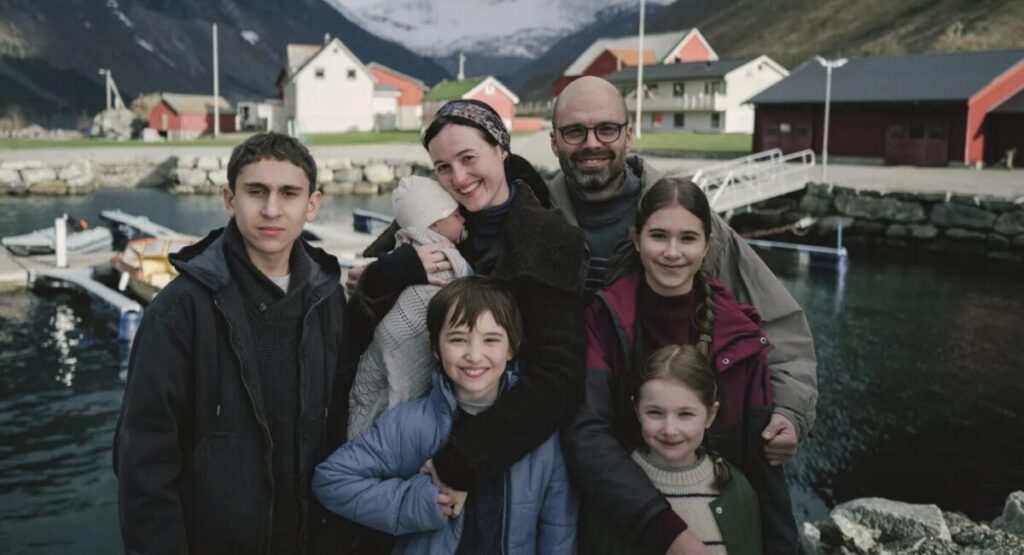 A family stands in front of a harbor