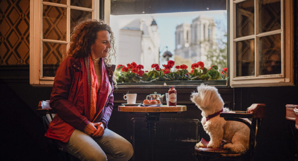 Woman with her dog at a cafe in Paris.