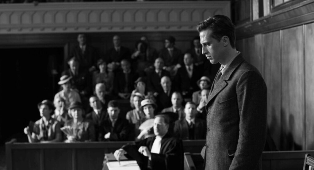 Man looks down somberly in front of jury.