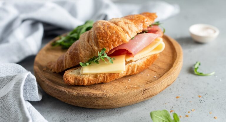 Sandwich with ham and cheese on croissant bun.