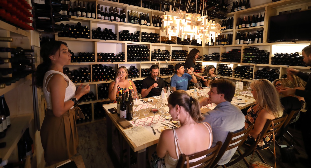 Wine tasting in a wine cellar with chandelier.