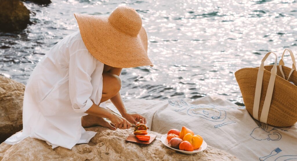 Rebekah Peppler cutting tomatoes by the sea