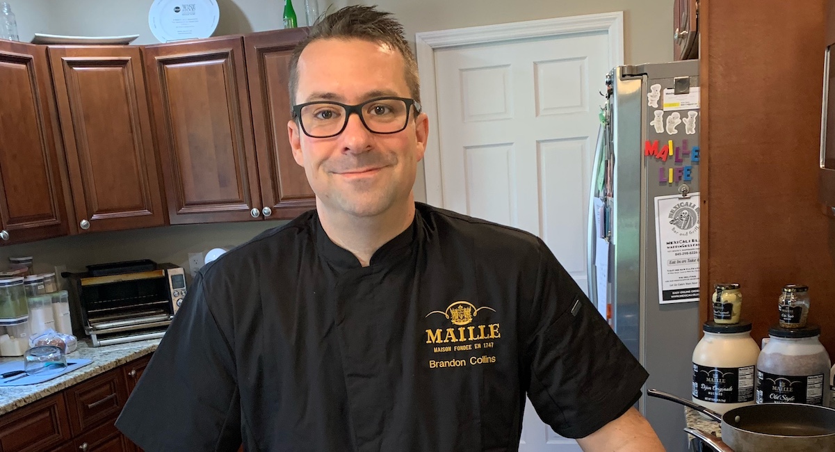 Chef in Maille brand shirt in kitchen