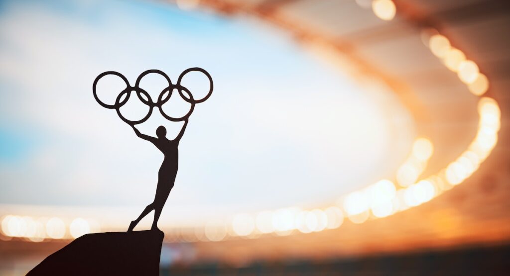 PARIS, FRANCE, JULY 7, 2023: Iconic Gesture: Statue of Athletics Woman Triumphantly Lifts Olympic Circle at Modern Olympic Stadium.