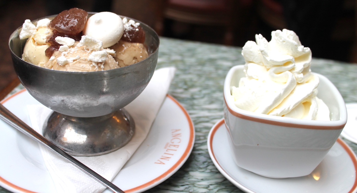 Bowl of ice cream beside china dish of whipped cream