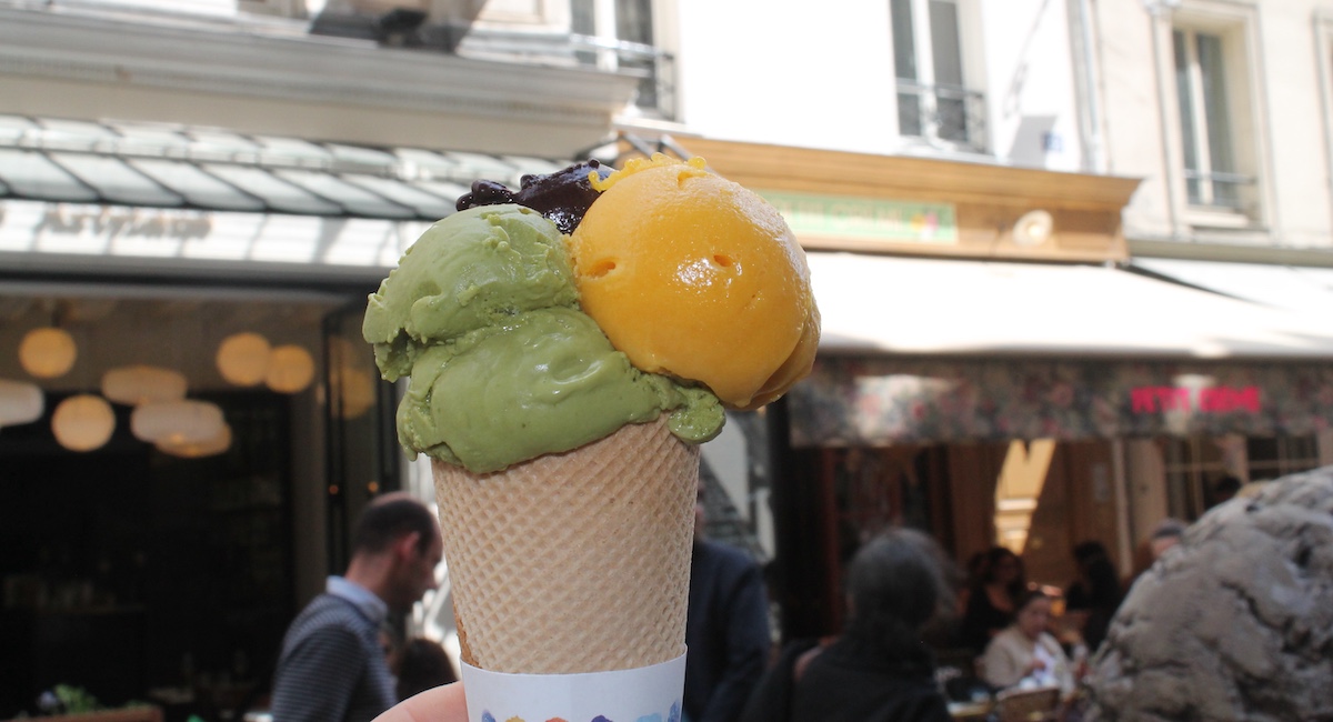 Close up on ice cream cone with green and orange scoops