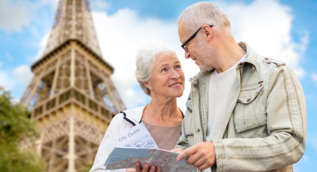 Senior couple with map and city guide over eiffel tower and blue sky background.