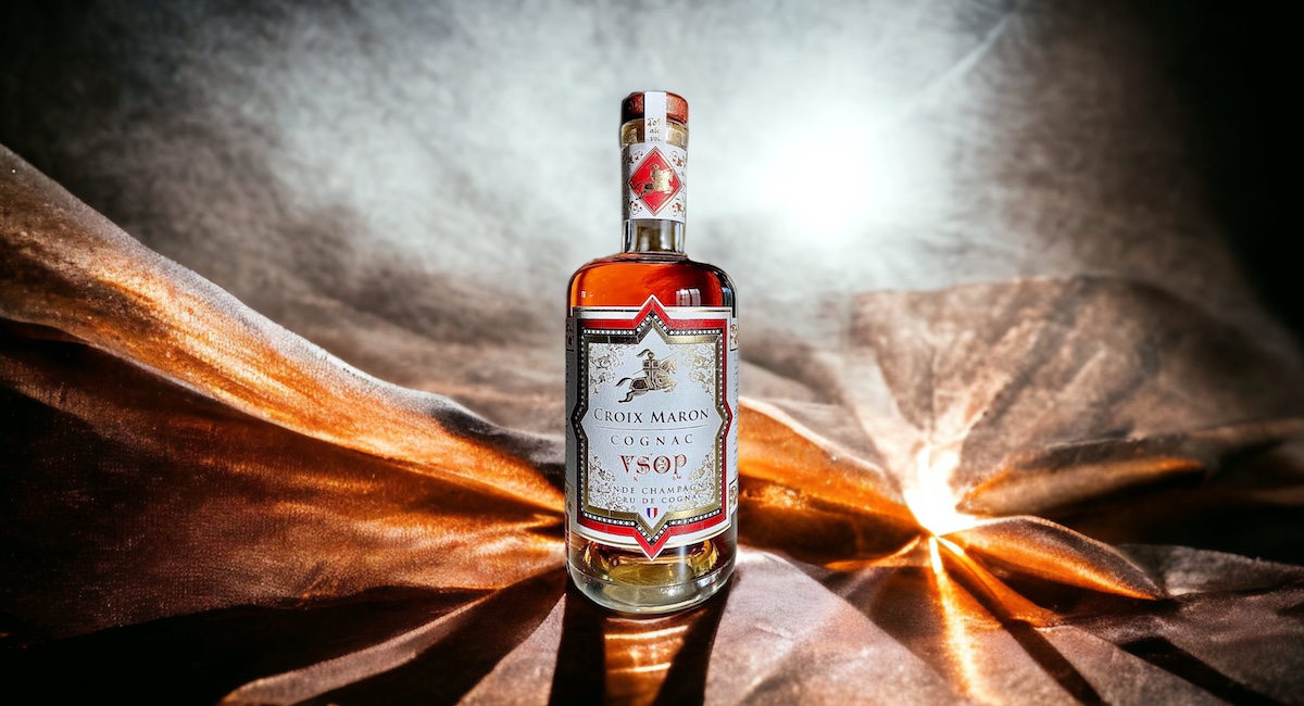 Cognac bottle against draped fabric backdrop