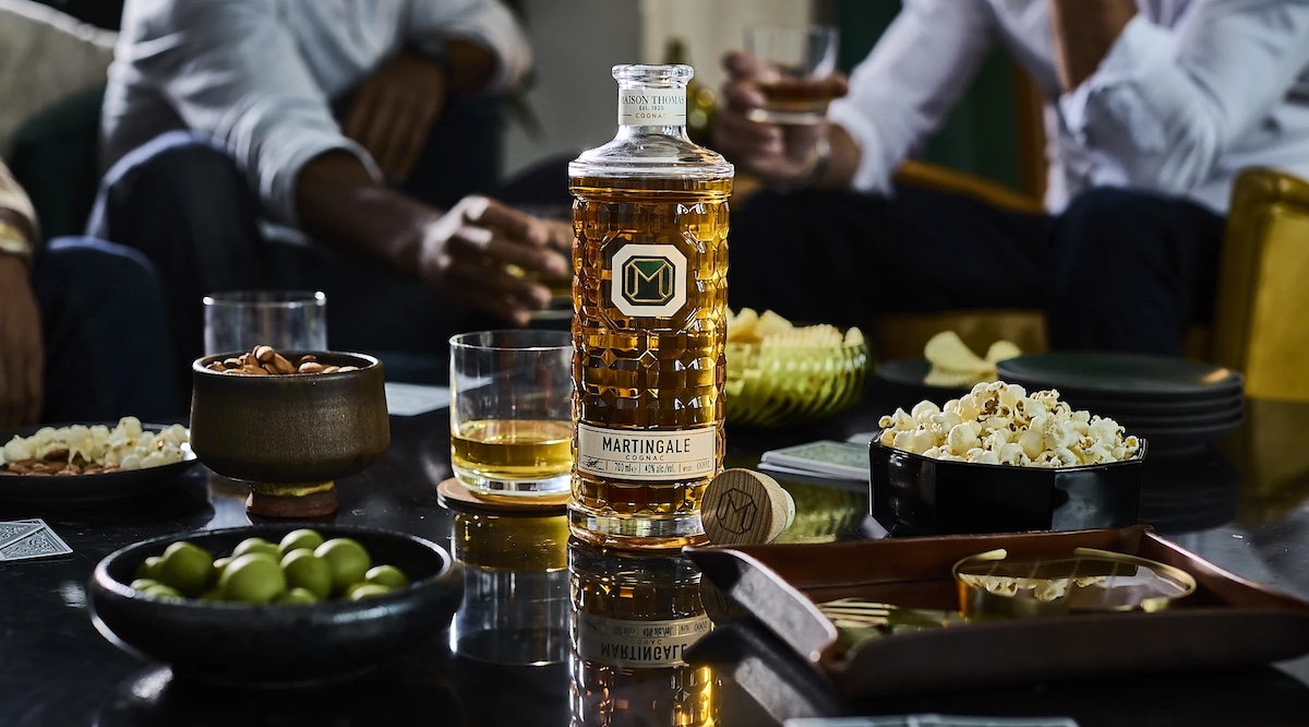 Bottle of cognac surrounded by popcorn and other snacks