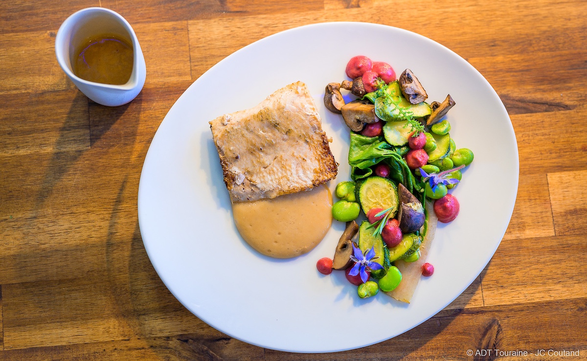 Fish in sauce with colorful vegetable salad