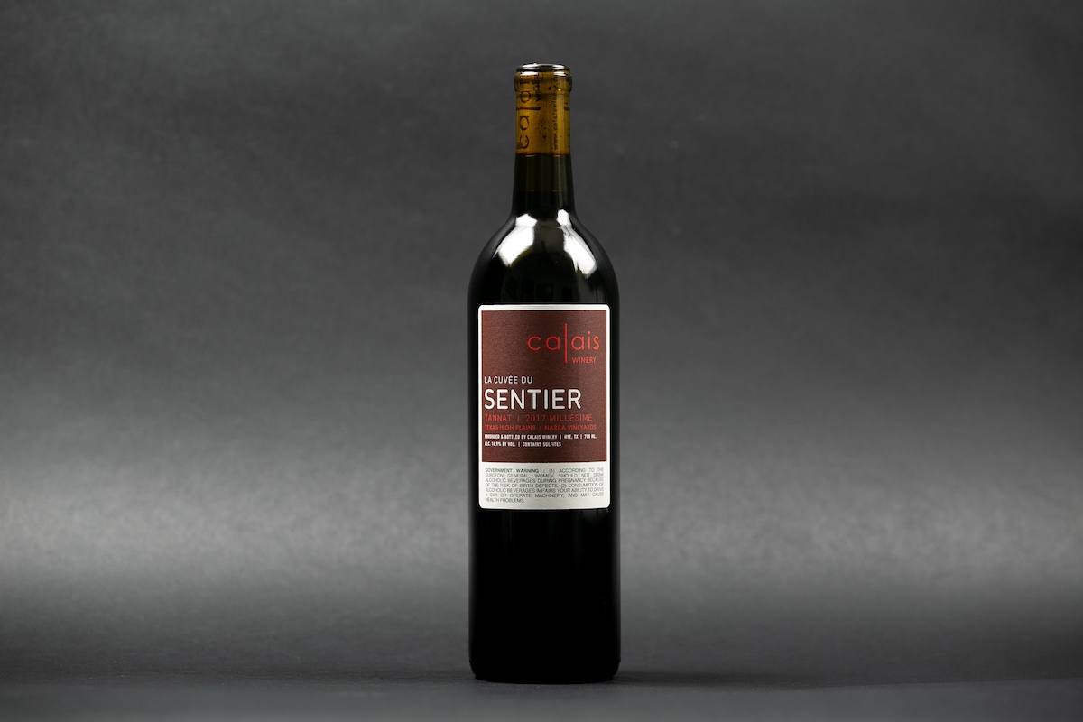 Bottle of red wine on gray backdrop