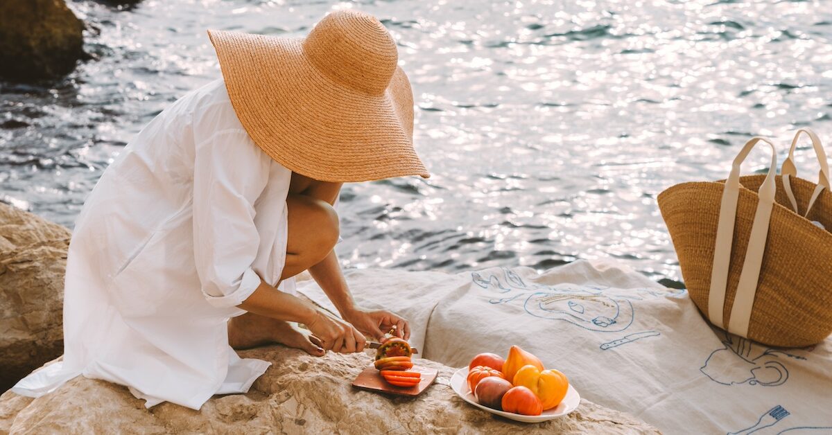 Woman cutting tomatoes on rocky outcropping
