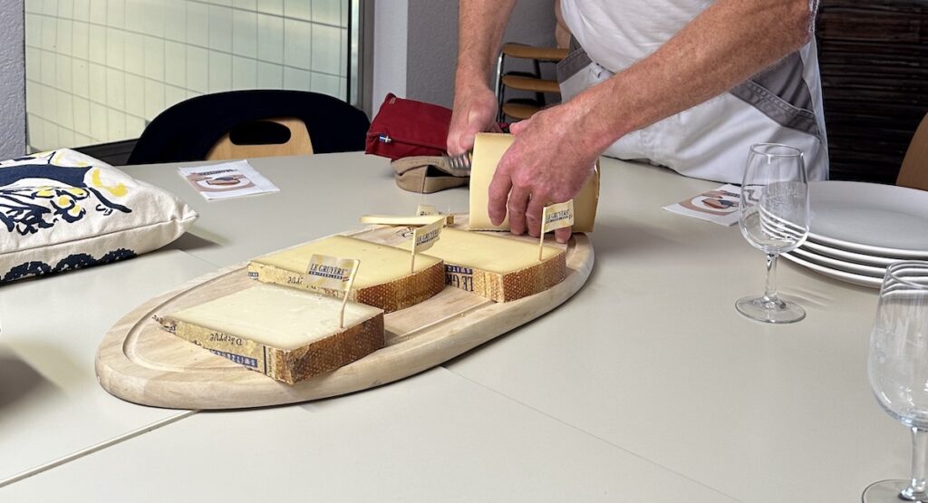 Wooden board with various cheeses on it