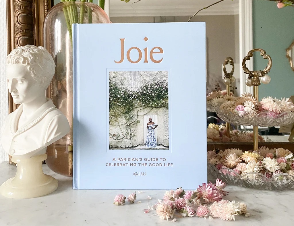 Baby blue book cover surrounded by dried flowers and plaster bust