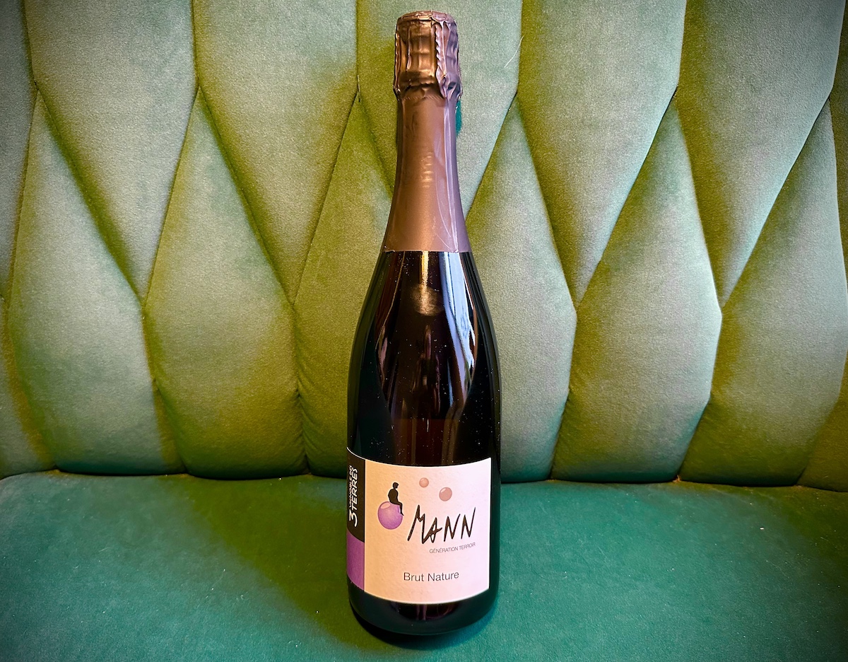 Bottle of sparkling wine against green velvet armchair