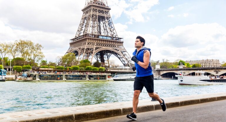 Man training and doing fitness exercises along the Seine river in Paris with Eiffel tower on background - Multiracial young man enjoying sport on a sunny day