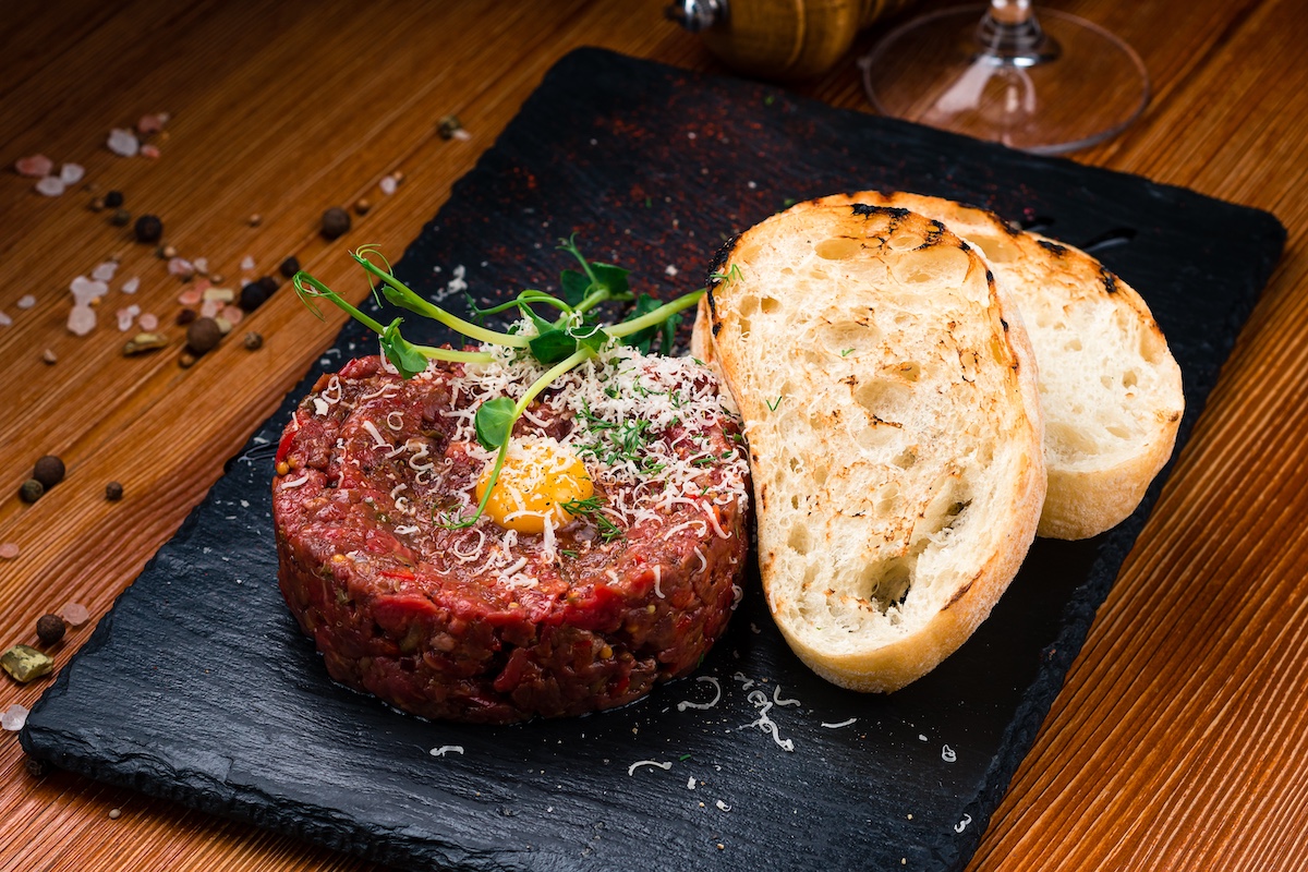 Beef steak tartare with raw egg yolk, with raw quail egg