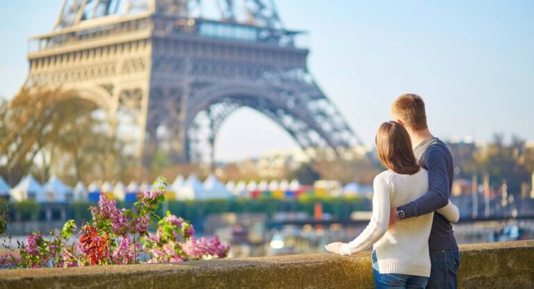 Couple looking at Eiffel Tower on a bridge strewn with flowers