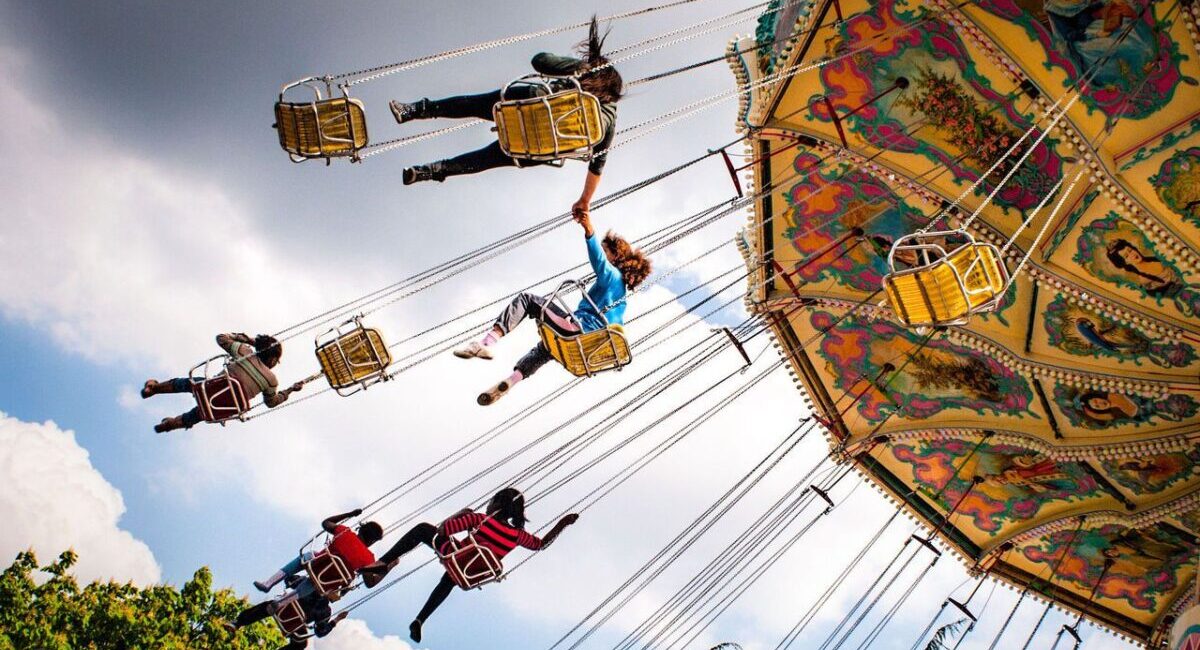 Children flying on swing ride at carnival.